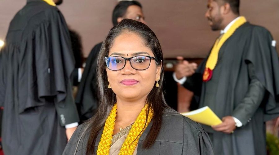 A graduate in her academic gown and garland at a graduation ceremony